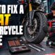 Rider using a plug kit for a motorcycle tire fix on a Pakistan roadside