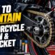 Mechanic oiling a motorcycle chain and sprocket in a Pakistan workshop